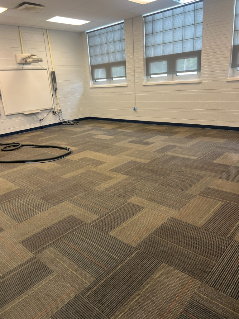 spacious room with carpeted floor and multiple windows