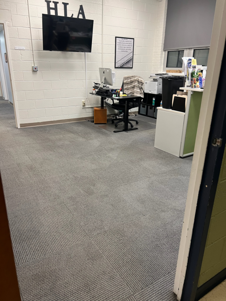 office space with carpeted floor for employees with desks, printers a television