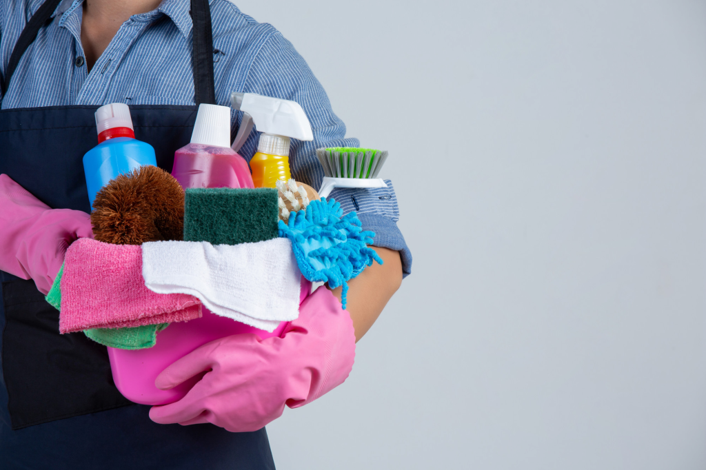 an individual holding a bunch a cleaning supplies