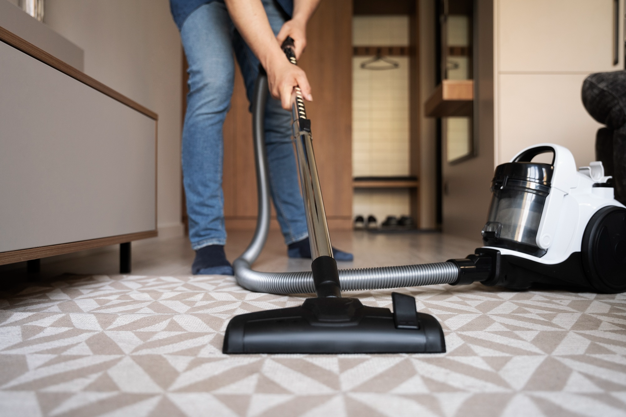 a closeup shot of an individual cleaning a carpet