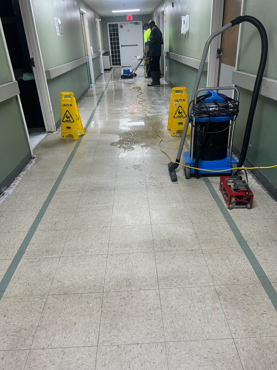 janitors using heavy cleaning machines to clean hospital hallway