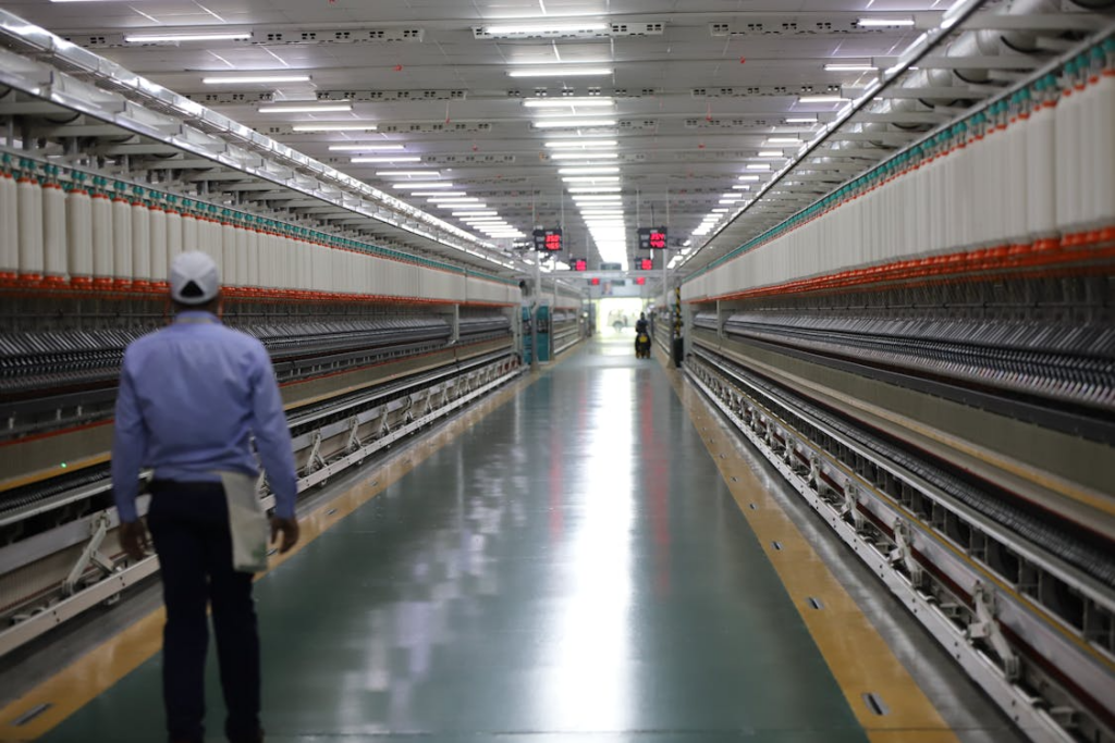A photo showing a person standing in a long hallway in an industrial facility.