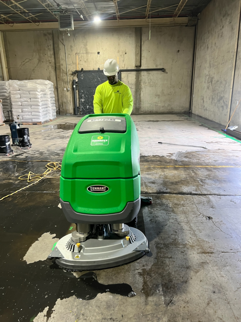 An image of a man cleaning an industrial facility floor